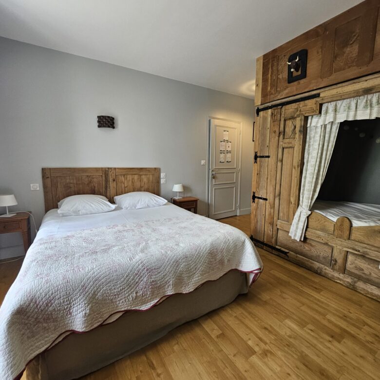 Vue d’ensemble de la chambre L’Auvergnate à la Datcha Anastasia, avec lit queen size et ambiance chaleureuse inspirée du terroir auvergnat