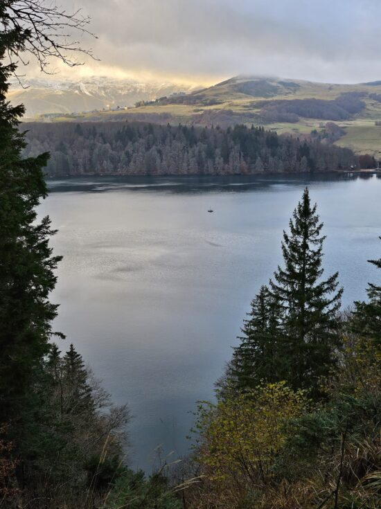 Vue panoramique sur le mystérieux Lac Pavin, entouré de forêts au cœur du Sancy.